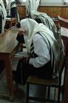 Jews praying in the synagogue with prayer shawl and phylacteries