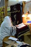 Jews praying in the synagogue with prayer shawl and phylacteries