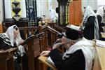 Jews praying in the synagogue with prayer shawl and phylacteries