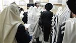 Jews praying in the synagogue with prayer shawl and phylacteries