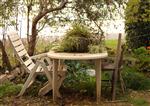 a table and two chairs in a garden