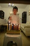ילד מדליק נרות חג החנוכה