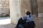 ילדה דוחפת עגלה בסמטאות מאה שערים בירושלים