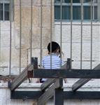 ילד יושב במרפסת במאה שערים בירושלים
