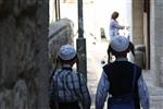 ילדים חסידים עם כיפות לבנות הולכים בסמטא במאה שערים בירושלים