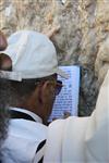 יהודי מתפלל מתוך ספר תהלים בכותל המערבי בירושלים