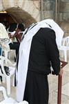 יהודי מתפלל נשען על סטנדר בכותל המערבי