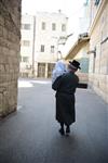 Child being led a prayer shawl towards income study cheder