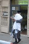 Child being led a prayer shawl towards income study cheder