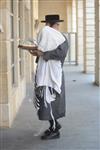 Child being led a prayer shawl towards income study cheder