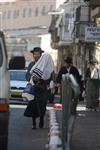 Child being led a prayer shawl towards income study cheder