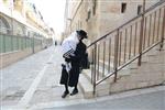 Child being led a prayer shawl towards income study cheder