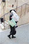 Child being led a prayer shawl towards income study cheder