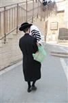 Child being led a prayer shawl towards income study cheder