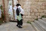 Child being led a prayer shawl towards income study cheder