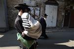 Child being led a prayer shawl towards income study cheder