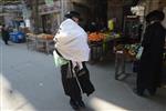 Child being led a prayer shawl towards income study cheder