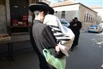 Child being led a prayer shawl towards income study cheder