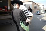 Child being led a prayer shawl towards income study cheder